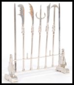 A set of Chinese silver cocktail sticks in the form of weapons in a decorative stand having