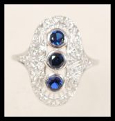 A stamped silver Art Deco style ring having an oval form central panel set with diamonds and three