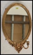 A 19th century Victorian oval gilt plaster wall / overmantel mirror being of rococo inspiration