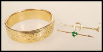 A vintage 1/5 th  9ct gold bangle bracelet with metal core together with two bar brooches