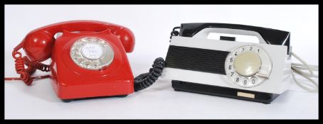 Two retro vintage 20th Century ring dial telephones - phones one in red with phone atop and the