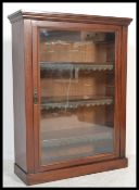 An Edwardian mahogany pier cabinet being raised on a plinth base with single glass door, shelved