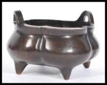 A 19th Century Chinese bronze censer ding bowl of bulbous segmented form raised on four stub feet