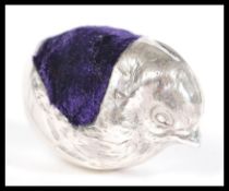 A silver pincushion in the form of a chick having a blue velvet cushion to the back. 4.5cm high 4.