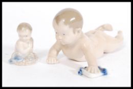 Two Royal Copenhagen figurines of Cherubs including a Piano Baby 1739 and a Mermaid 2313. Printed