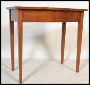 A Georgian style mahogany side / lamp table being raised on square tapering legs with serpentine