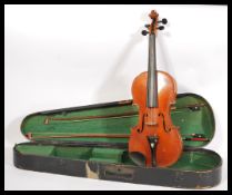 An early 20th Century violin musical instrument having a two piece maple back and spruce front.