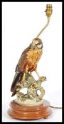 A 20th Century ceramic table lamp in the form of a bird of prey, the bird sat on a naturalistic base