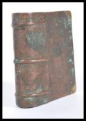 An early 20th Century novelty cigarette lighter in the form of a book, having a hinged lid and