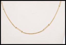 A stamped 750 18ct gold necklace having a fine chain with crossover design spacers and lobster