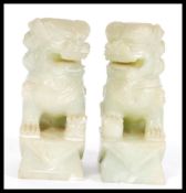 A pair of vintage 20th Century Chinese carved green stone fu dogs, the dogs in seated position