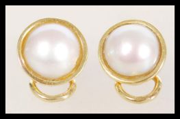 A pair of 18ct gold front and back plated gold clip on earrings of roundel form having large central