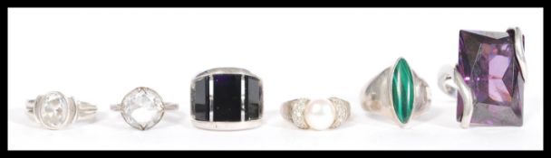A selection of 925 silver rings to include a ring set with a large rectangular purple stone, a