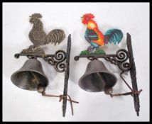 Two 20th century hand painted exterior cast iron metal wall hanging bells. Each with a hand