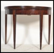 A 19th century George III mahogany demi lune tea table / games card table. Raised on square tapering