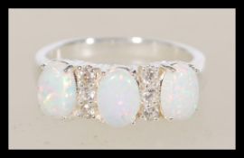A sterling silver opal ring having three opal panels with CZ spacers.
