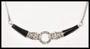 A sterling silver and onyx necklace having a flat curb link with two panthers joint by a ring.