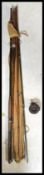 A collection of early 20th Century vintage split cane fly fishing rods some having cork handles