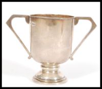 A hallmarked early 20th century silver twin handled goblet / trophy cup raised on stepped circular