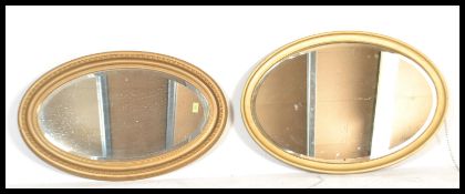 Two 19th century Victorian gilt wood oval wall mirrors. Each oval cushion frame with shaped design