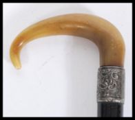 A 19th century silver hallmarked collared walking stick cane having a tapering ebony shaft with
