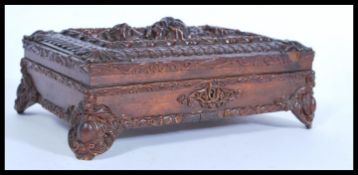 An early 20th century Edwardian carved oak writing box having carved feet, key escutcheon and lid.