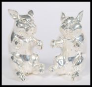 A pair of silver condiments in the form of pigs sitting on their hind legs. Weight 104.7g. 5cm high.