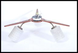 A vintage retro 20th Century 1950's teak boomerang lamp having three opaque glass shades.