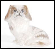 A Royal Copenhagen ceramic dog figurine of sitting Pekingese model number 1772. Painted and