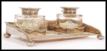 An early 20th Century silver hallmarked desk stand having two cut glass and silver lidded ink pots
