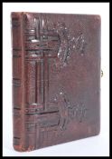 A vintage 20th Century photograph album having a leatherette cover with illustrated decorative pages