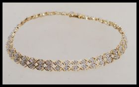 A hallmarked 9ct gold bracelet chain having a criss cross link with illusion set diamond spacers and