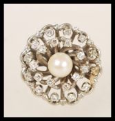 A 14ct white gold diamond and pearl cluster ring having a central pearl with two halos of