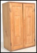A 19th century Victorian pine school cupboard having twin fielded panel doors with inset shelves set