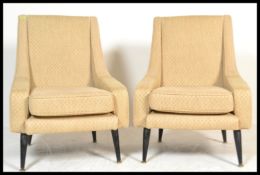 A pair of mid 20th century vintage / retro armchairs - wedge chairs being raised on turned