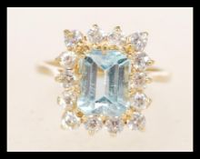A 9ct gold hallmarked ring set with a rectangular light blue stone with white accent stones.