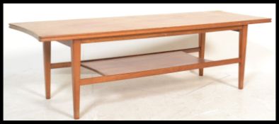 A mid century Danish influence teak wood long john coffee - occasional table being raised on