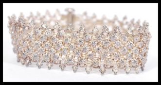 A vintage early 20th century Asiatic silver white metal mesh bracelet with floral head spacers and