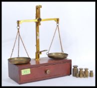 A set of vintage 20th Century brass spice / jewellery balance scales raised on a wooden base with