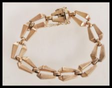 A hallmarked 9ct gold bracelet with stylised Egyptian revival links having safety chain and catch.