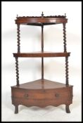 A 19th century Victorian waterfall mahogany and barley twist whatnot etagere having barley twist