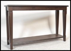 A 20th century contemporary oak console table of rectangular form having square tapering legs united