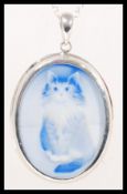 A sterling silver necklace and pendant having a ceramic cameo plaque depicting a Persian cat.