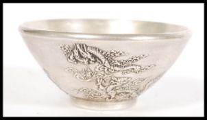 An early 20th Century Chinese silver plated prayer bowl of conical form having relief decoration