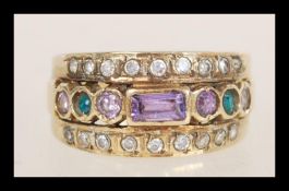 A 9ct gold ring set with a row of purple and green stones flanked by two rows of white stones.