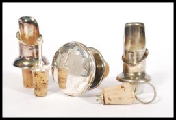 A group of five vintage early 20th century silver plated bottle stoppers and pourers some having