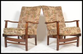A pair of 1940's fireside armchairs in the manner of Heals of London. Each with mahogany frames