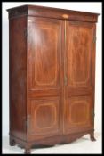 A 19th century mahogany inlaid double wardrobe being raised on French bracket kick feet with fielded