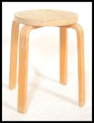 A mid century Alvar Aalto model 60 bentwood ply stool with circular seat being raised on bentwood