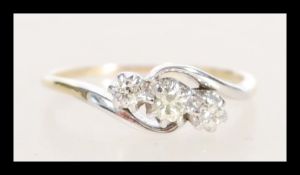 A stamped 14ct gold crossover ring prong set with three brilliant cut diamonds. Weight 2.7g. Size